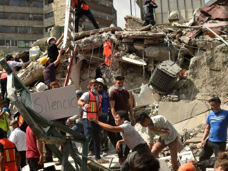  Les secouristes affichent une lecture de placard & Silence & # 39; Alors qu'ils se dépêchent de libérer des victimes possibles des décombres d'un bâtiment effondré après un tremblement de terre qui a secoué la ville de Mexico le 19 septembre 2017 