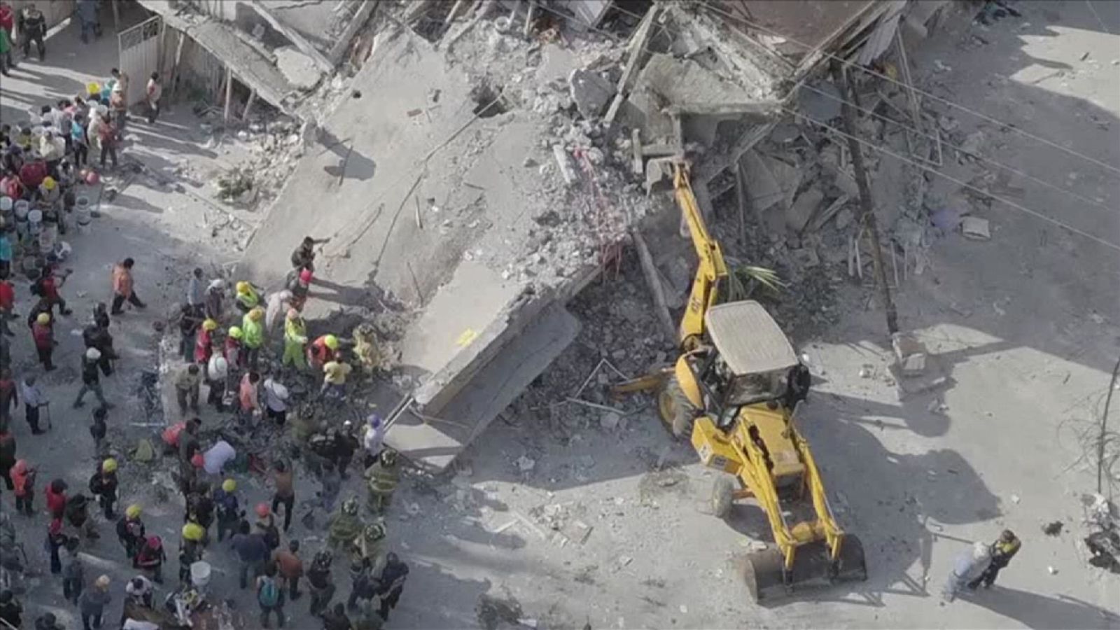  Vue aérienne des secouristes et des excavatrices à côté du bâtiment effondré. 