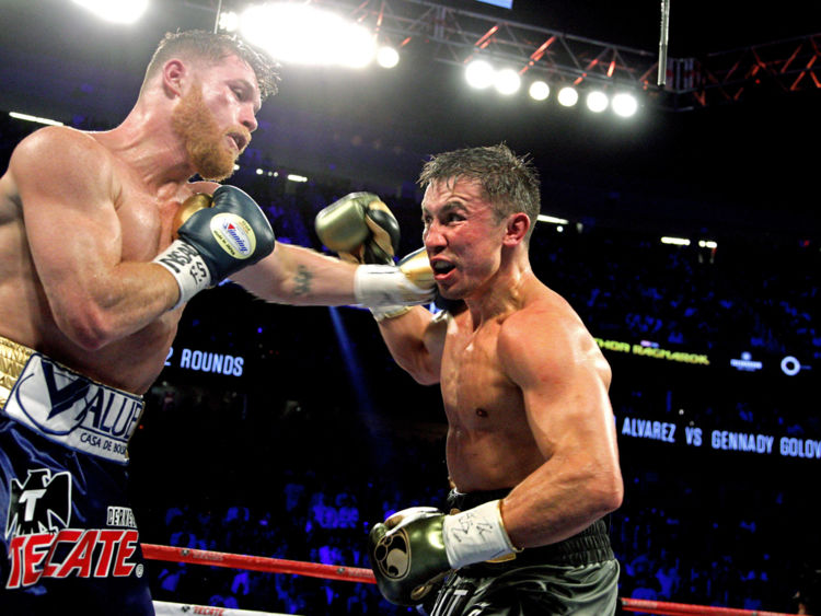  Canelo Alvarez (L) déclenche un crochet de gauche contre Gennady Golovkin (R) lors de son championnat WBC, WBA et IBF de poids moyen au T-Mobile Arena le 16 septembre 2017 à Las Vegas, au Nevada. Gennady Golovkin a conservé ses trois titres de poids moyen du monde, en luttant contre un tirage au sort avec l'étoile mexicaine Canelo Alvarez lors d'une épreuve pour la suprématie des moyens qui a marqué le battage médiatique. / AFP PHOTO / John GURZINSKI (Le crédit photo doit être lu JOHN GURZINSKI / AFP / Getty Images) 