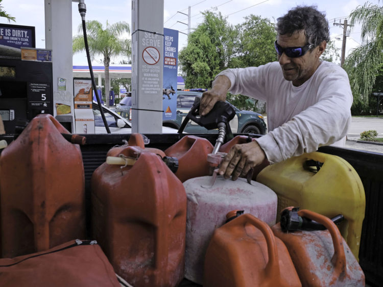  Robert Johnson remplit des conteneurs de gaz dans une station-service à Miami, en Floride, le 8 septembre 2017, devant l'ouragan Irma. Le gouverneur de la Floride, Rick Scott, a prévenu que tous les 20 millions d'habitants de l'État devraient être prêts à évacuer alors que l'ouragan Irma se débrouille pour un coup direct sur le sud des États-Unis. / AFP PHOTO / Gaston De Cardenas (Le crédit photo doit être lu GASTON DE CARDENAS / AFP / Getty Images) 