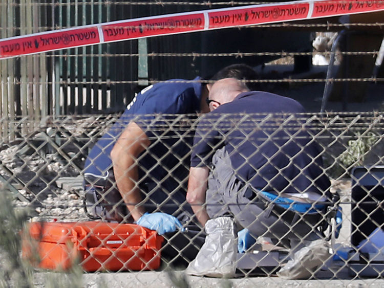  Les agents de médecine légale recueillent des preuves sur le site de l'attaque à l'entrée de la colonie de Cisjordanie Har Adar 