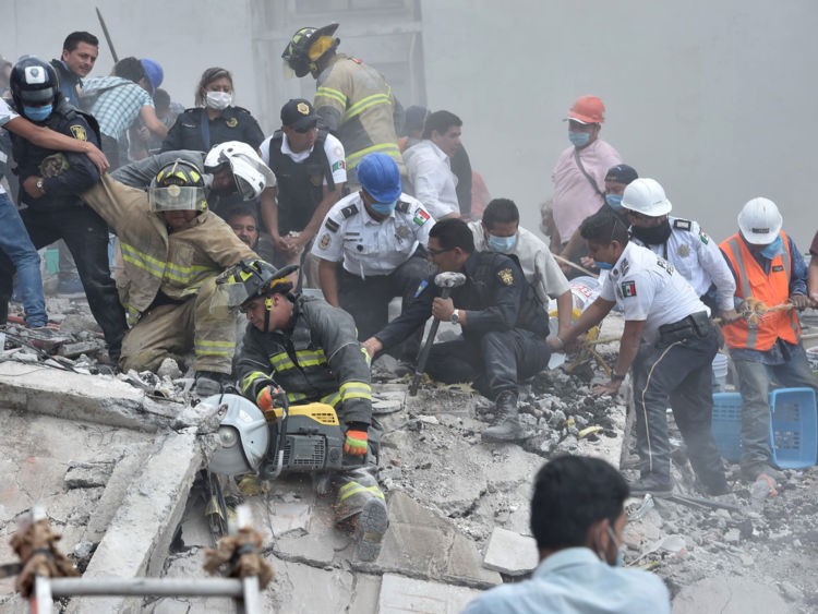  Les secouristes, les pompiers, les policiers, les soldats et les volontaires enlèvent les débris et les débris d'un bâtiment aplati à la recherche de survivants après un puissant tremblement de terre à Mexico le 19 septembre 2017 