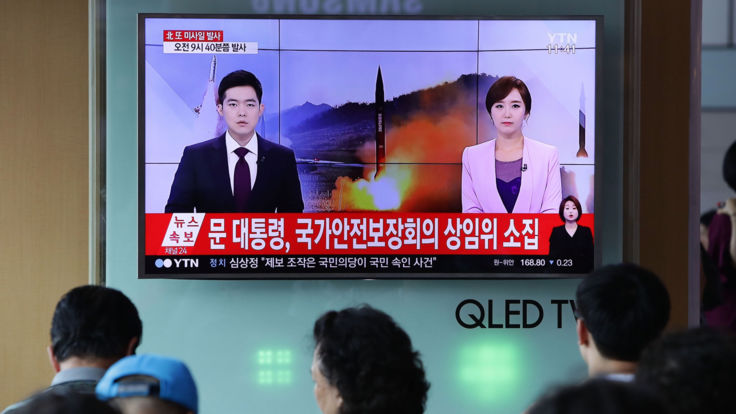  Les gens regardent les rapports télévisés sud-coréens du lancement ICBM 