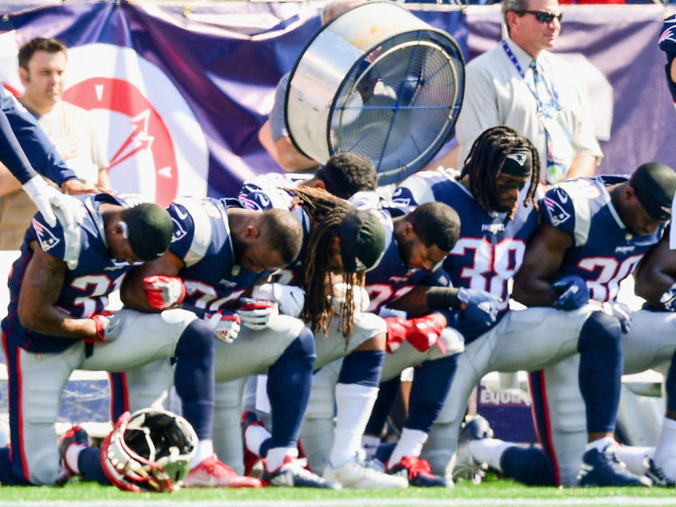  Les membres des New England Patriots s'agenouillent en marge lorsque l'hymne national est joué avant un match contre Houston Texans au Gillette Stadium 