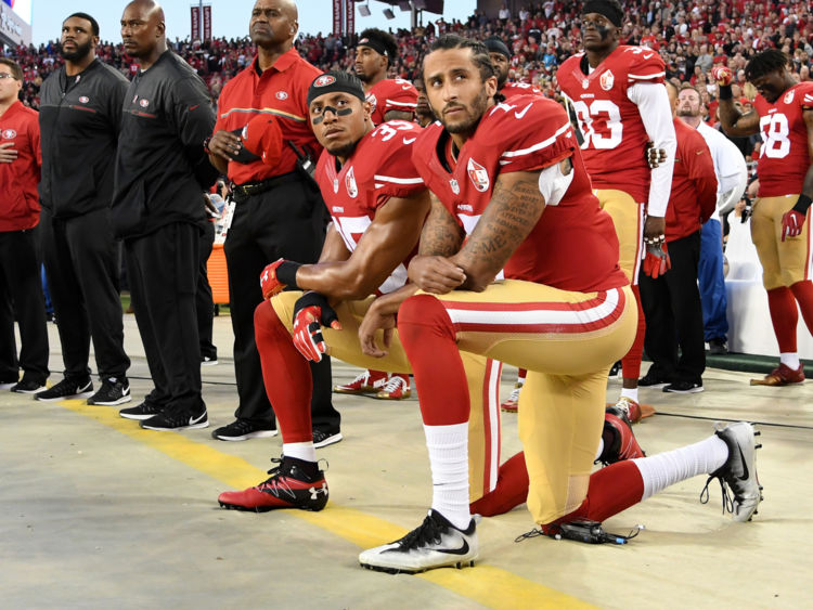  Colin Kaepernick # 7 et Eric Reid # 35 s'agenouillent pendant le Star Spangled Banner avant la victoire sur les Rams 