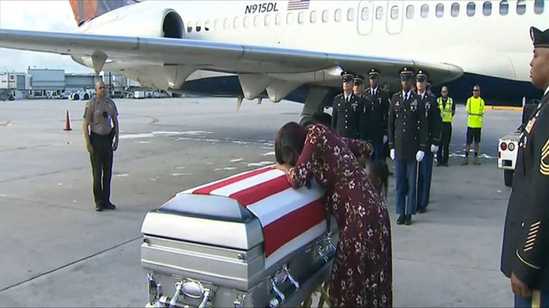  La femme du Sgt La David Johnson pleure sur son cercueil alors que son corps est retourné à Miami 