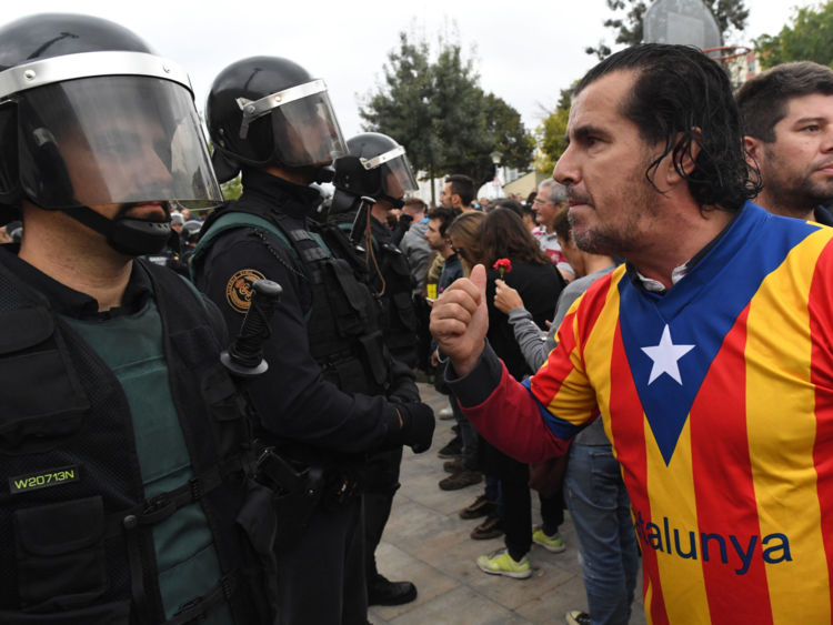  Un homme vêtu du drapeau catalan face aux officiers 
