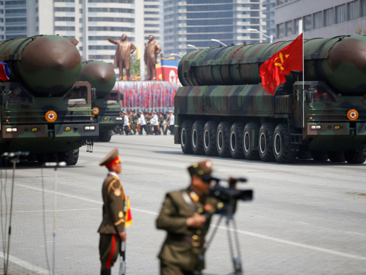  PHOTO DU FICHIER: Les missiles balistiques intercontinentaux (ICBM) passent le stand avec le dirigeant nord-coréen Kim Jong Un et d'autres hauts responsables lors d'un défilé militaire marquant le 105e anniversaire de naissance du père fondateur du pays, Kim Il Sung, à Pyongyang le 15 avril 2017. Les missiles eux-mêmes ont été montrés pour la première fois Le temps passé à l'intérieur d'un nouveau type de lanceur à cartouche samedi 