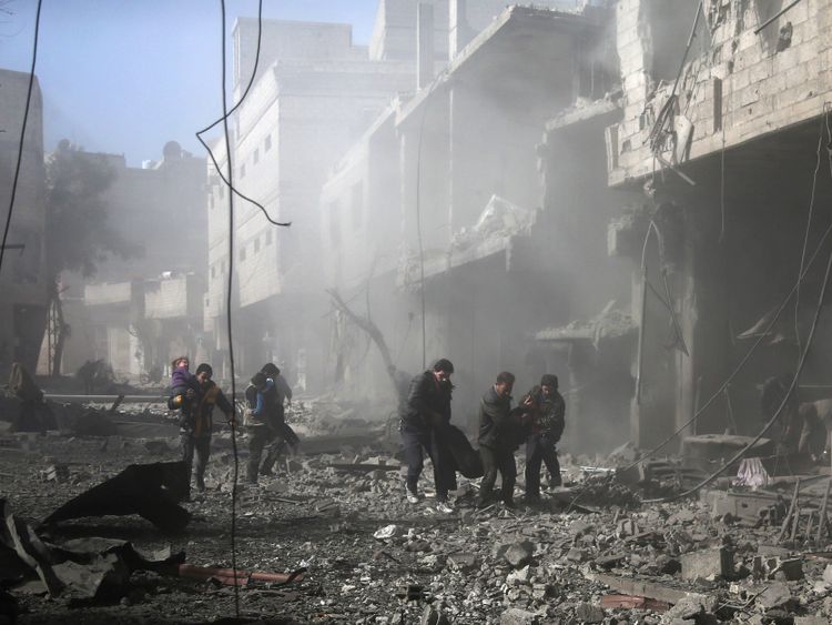  Des hommes syriens transportent une victime blessée parmi les décombres des bâtiments suite aux bombardements du gouvernement. la ville tenue par les rebelles de Hamouria 