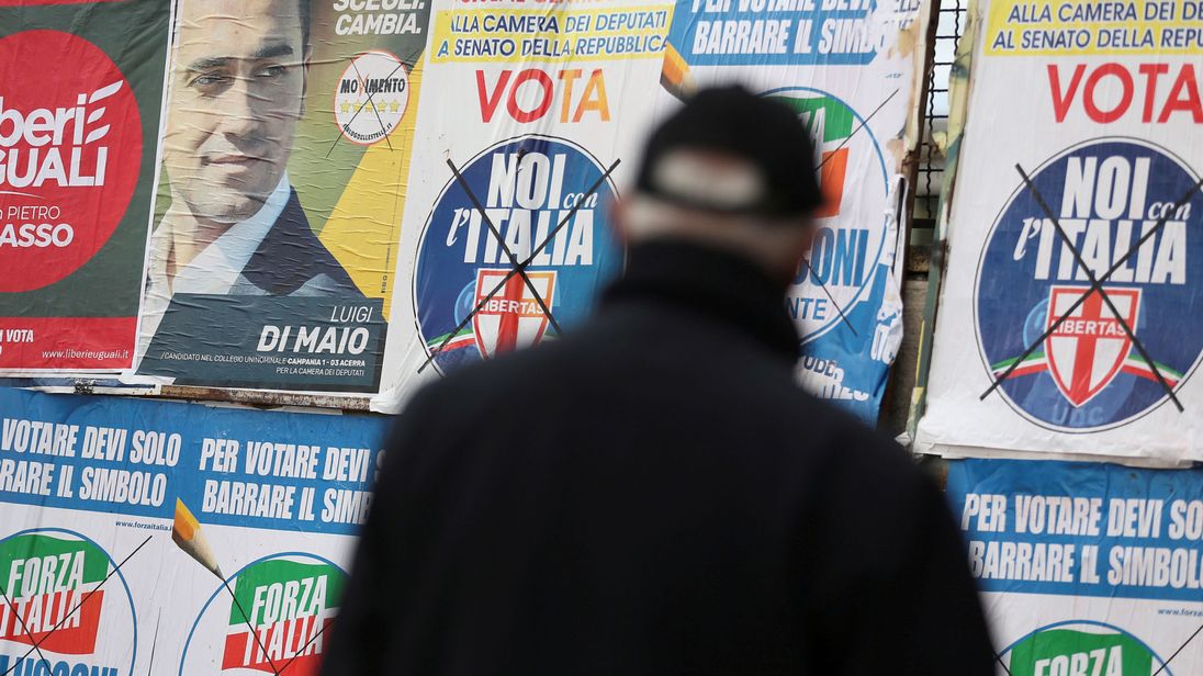 Un homme à l'affût des affiches électorales à Pomigliano D'Arco, près de Naples, en Italie, 21 février 2018 