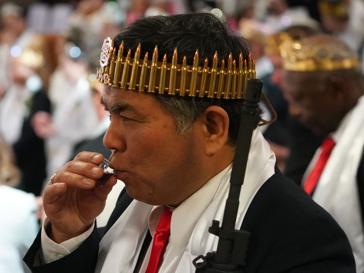  Un homme portant une couronne de carabines prend la communion 