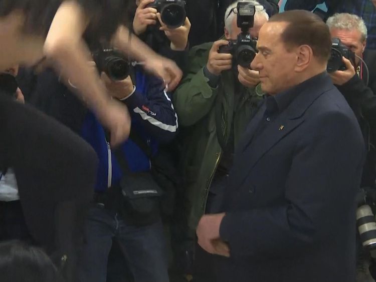  M. Berlusconi posait pour des photographes quand la femme sautait sur une table devant lui 