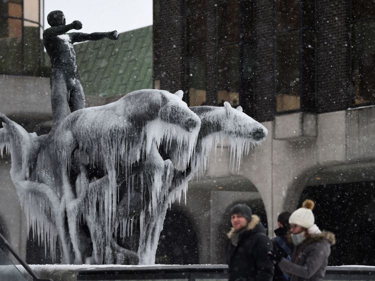  Les gens passent devant une statue gelée à Dublin 