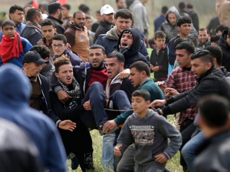  Un adolescent palestinien blessé est porté par d'autres manifestants alors qu'ils fuient lors d'affrontements 