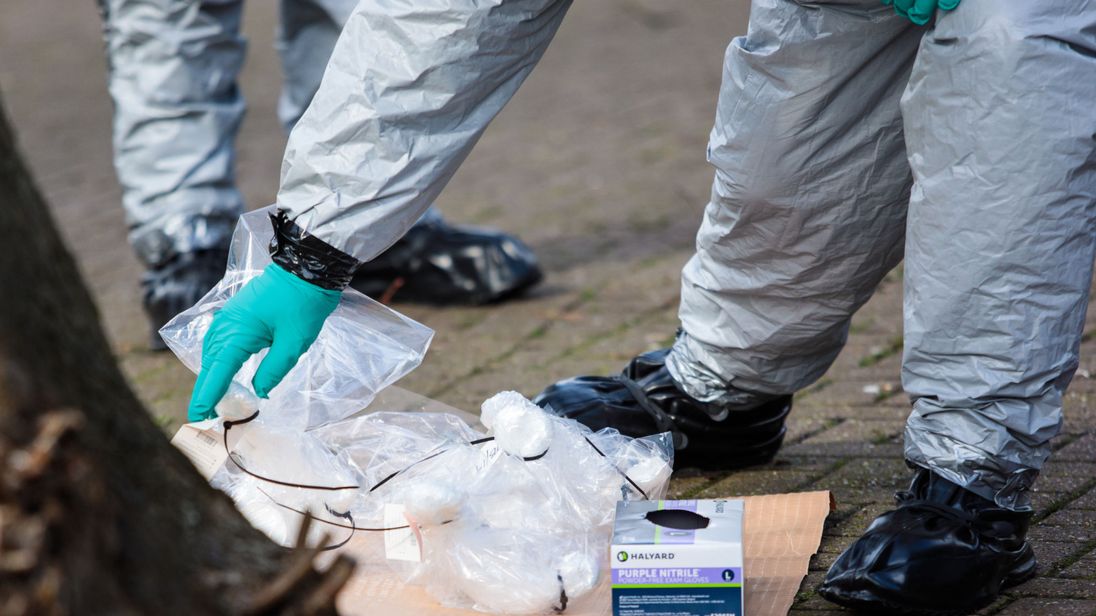  Les policiers en tenue de protection et masques recueillent des échantillons près du banc où ils ont été trouvés 