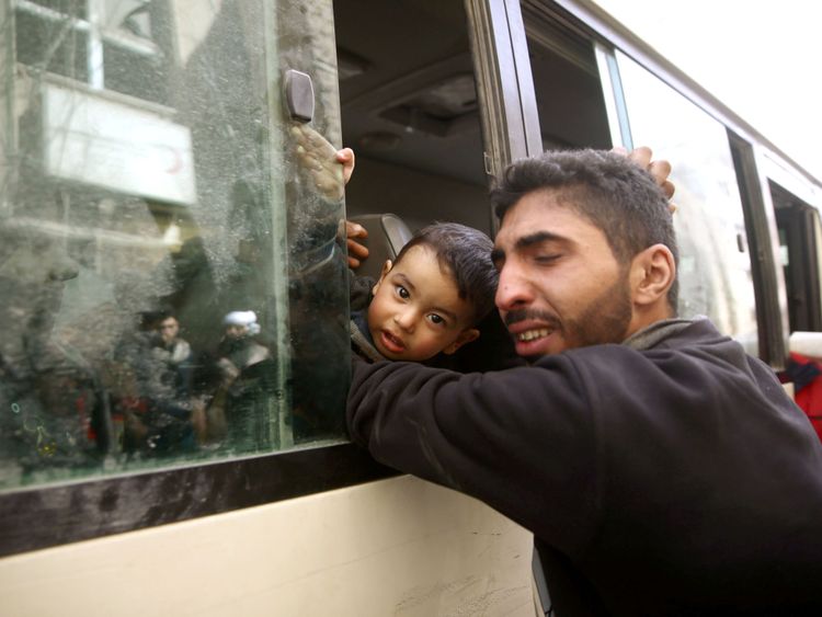  Un homme embrasse un enfant alors qu'il est évacué de l'Est Ghouta </span><br />
        <span class=