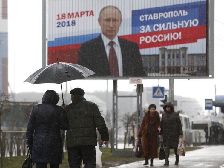  à côté de l'affiche de la campagne électorale du président russe Vladimir Poutine à Stavropol, en Russie, le 14 mars 2018. Le conseil lit 
