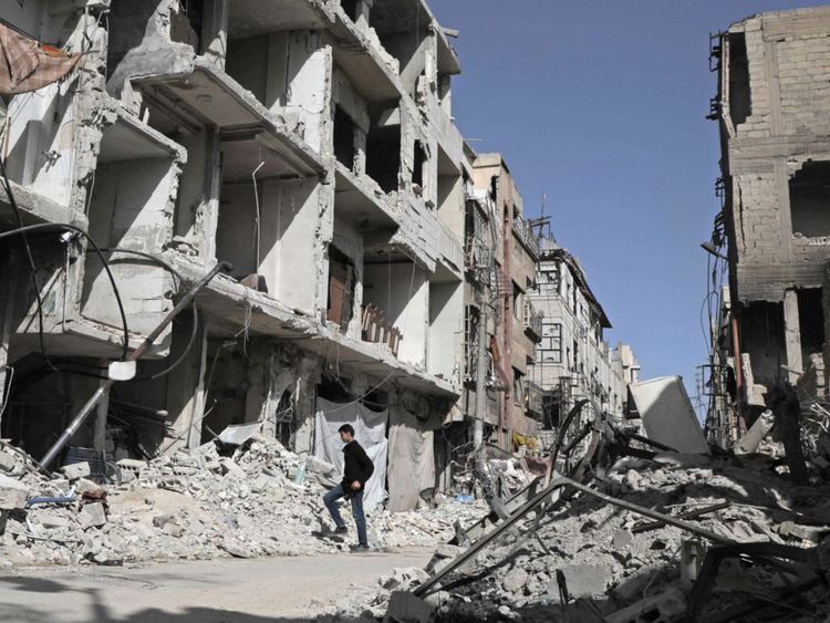  Un Syrien descend une rue Le 25 mars 2018, à Douma, des bâtiments détruits ont été détruits 