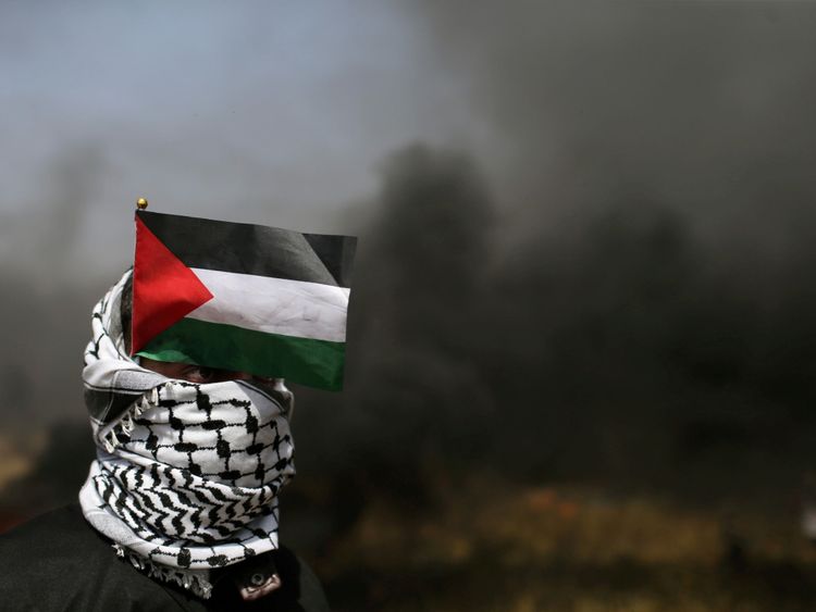  Un démonstrateur avec un drapeau palestinien regarde pendant les affrontements avec les troupes israéliennes 