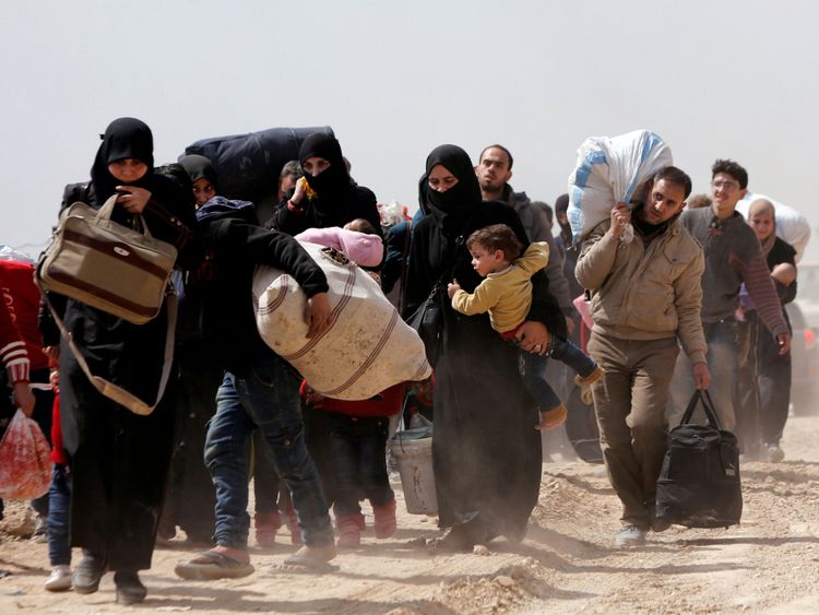 Les gens marchent avec leurs affaires alors qu'ils fuient la ville rebelle de Hammouriyeh, Ghouta orientale 
