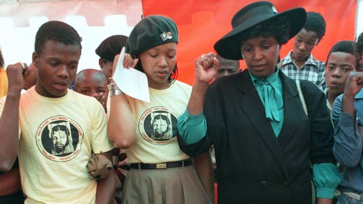  JOHANNESBURG, AFRIQUE DU SUD: Photo du 24 janvier 1987 montrant Winnie Madikizela-Mandela (R, avec chapeau) avec sa fille Zinzi (2e L) et Des membres du club de football Mandela ont chanté des slogans politiques à Soweto lors des funérailles d'un des membres de l'équipe tués dans des affrontements politiques. Madikizela-Mandela comparaîtra à l'audience de la Commission de vérité et de réconciliation (CVR) pour témoigner sur les allégations de sa participation à la mort de jeunes activistes politiques, bien qu'un témoin clé, Katiza Cebekhulu, </span><br />
        <span class=
