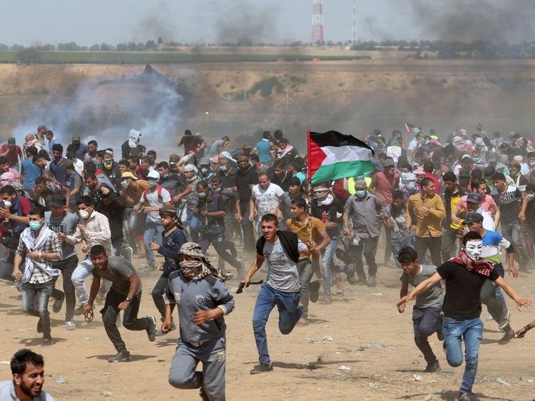  Des manifestants palestiniens se sont mis à couvert des gaz lacrymogènes tirés par les forces israéliennes 