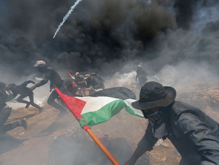  Des manifestants palestiniens se cachent du gaz israélien lors d'une manifestation contre l'ambassade américaine à Jérusalem et devant le 70ème anniversaire de la Nakba, à la frontière entre Israël et Gaza, dans le sud de la bande de Gaza. , 2018. REUTERS / Ibraheem Abu Mustafa 