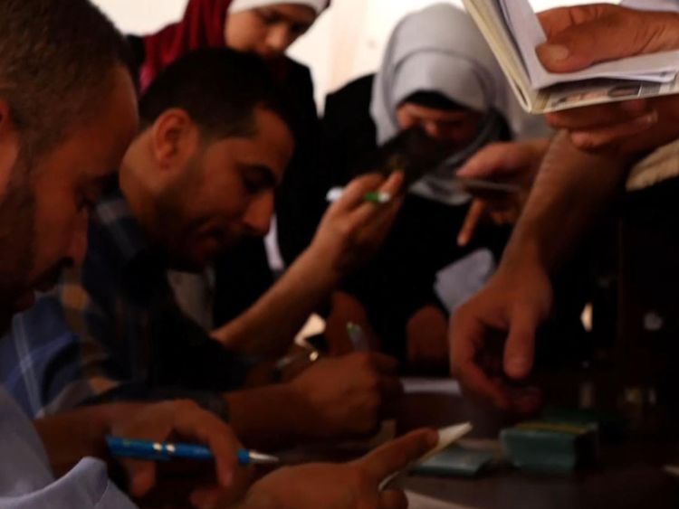  Les Palestiniens essaient de mettre de l'ordre dans leurs documents pour pouvoir monter dans un bus en Egypte 