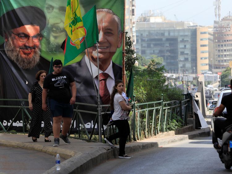  Les gens passent devant une bannière de campagne montrant le président du Parlement libanais et candidat aux élections législatives Nabih Berri et le leader du Hezbollah Sayyed Hassan Nasrallah à Beyrouth, au Liban, le 4 mai 2018. REUTERS / Jamal Saidi 