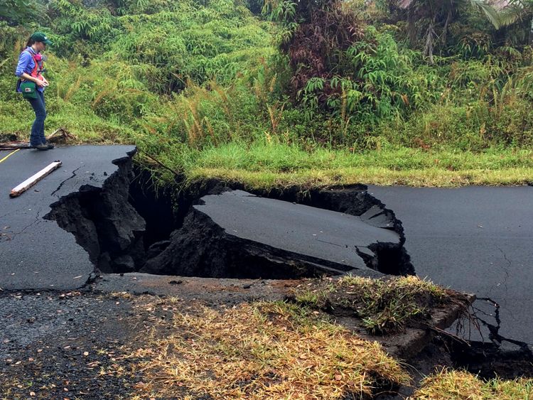  Un géologue inspecte les fissures sur une route après l'éruption du Kilauea volcan 