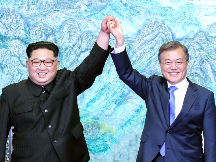  Kim Jong Un (L) et Moon Jae-in (R) lèvent la main lors d'une cérémonie de signature 