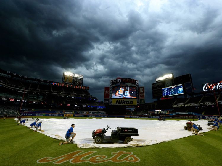  L'équipe des terrains de Citi Field à New York tient une couverture au-dessus du terrain de baseball alors que la tempête arrive 