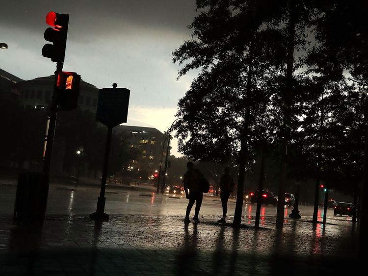  Des gens se tiennent sous les arbres alors qu'un violent orage survient au Capitole à Washington DC 