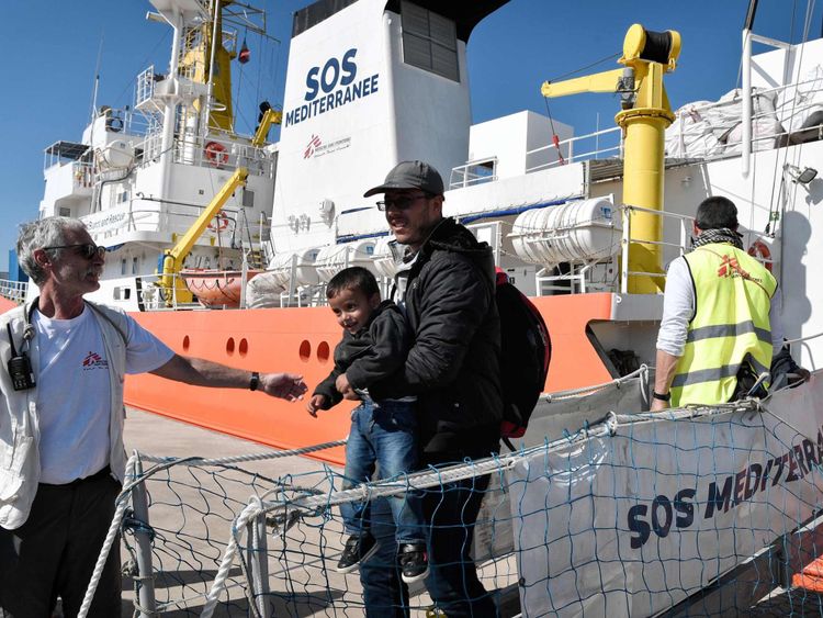 Un migrant et son enfant débarquent du MV Aquarius le mois dernier 