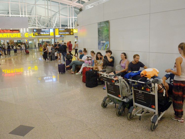 Les passagers sont attendus en attente de vols à l'extérieur du terminal international de l'aéroport Ngurah Rai après ...