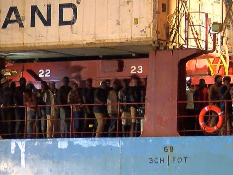 TOPSHOT - Dans cette vidéo prise le 26 juin 2018 à partir d'une vidéo de l'AFP, des migrants rescapés sont attendus pour débarquer du porte-conteneurs danois Alexander Maersk, au port de Pozzallo, en Sicile. - Un cargo danois appartenant à Maersk, première société de transport de conteneurs du monde, a accueilli lundi 108 personnes à son arrivée dans le port de Pozzallo, au sud de la Sicile, après avoir attendu trois jours en mer pour recevoir des instructions des autorités italiennes