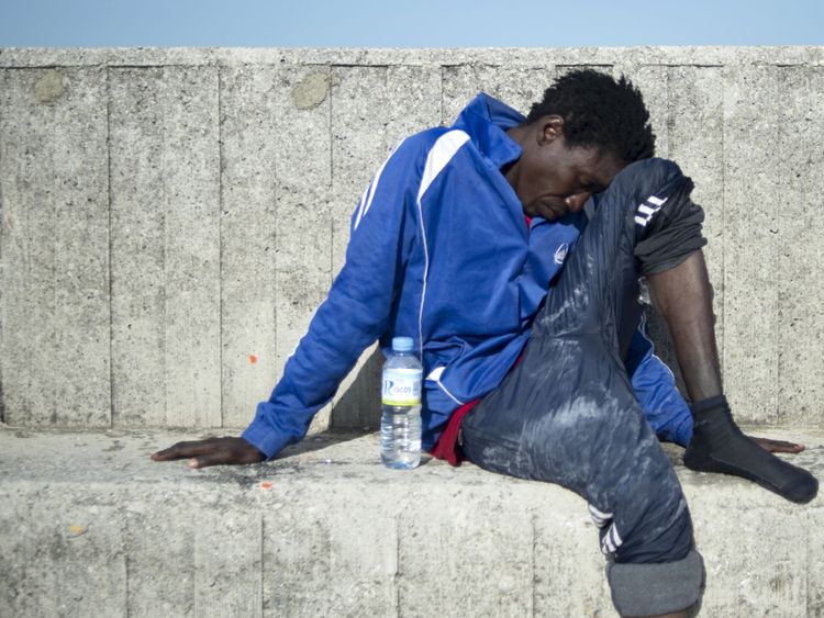 Un migrant se repose après être arrivé à bord d'un bateau de la garde côtière au port d'Algecira