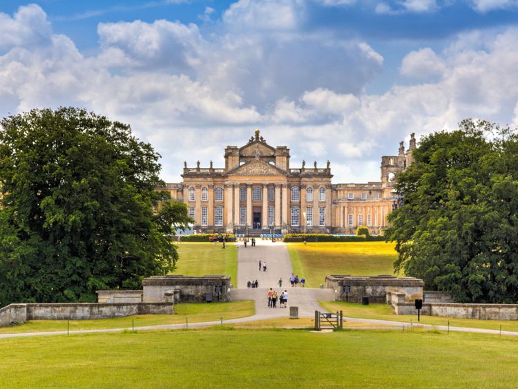 Woodstock, Royaume-Uni - 27 juin 2015: Blenheim Palace, Woodstock, Oxfordshire, Angleterre. C'est la résidence principale des ducs de Marlborough, et a été construite entre 1705 et 1722. Elle est employée comme maison de famille, mausolée et monument national. Le palais était aussi le lieu de naissance de Sir Winston Churchill. Un ciel bleu avec des nuages, une pelouse paysagée, des arbres verts et des touristes visitant le palais sont dans l'image.
