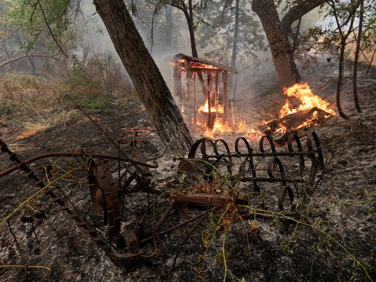 Une structure en bois brûle sur le bord sud du Carr Fire près d'Igo, en Californie