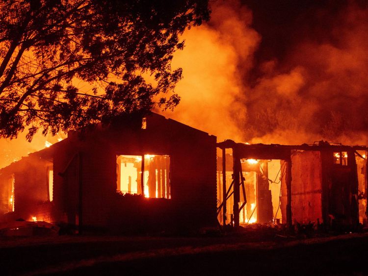 Une maison brûle pendant l'incendie de Carr à Redding, en Californie