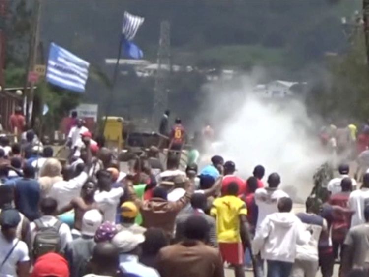 Les manifestants brandissent des drapeaux ambazoniens à mesure qu'ils avancent vers des barricades et la police au milieu des gaz lacrymogènes dans la ville anglophone de Bamenda