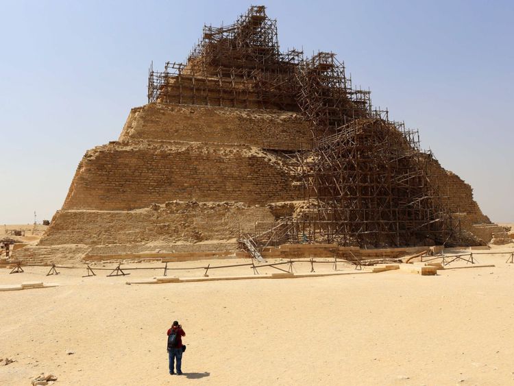 Des touristes prennent une photo de la pyramide à degrés de Djoser lors d'une visite à l'ancienne nécropole égyptienne de Saqqara, à environ 20 kilomètres au sud du Caire le 16 septembre 2014. L'Egypte a tenté de mettre fin à la controverse sur la restauration de la pyramide de Djose. de mettre en péril le célèbre monument pharaonique, datant de plus de 4 600 ans, en raison de travaux de restauration en cours. AFP PHOTO / MOHAMED EL-SHAHED (Crédit photo devrait lire MOHAMED EL-SHAHED / AFP / Getty Images)

