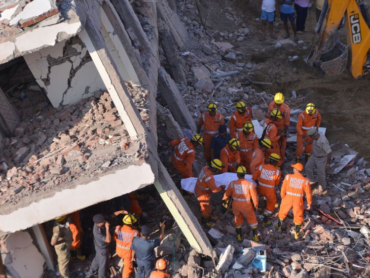 Les membres de la Force nationale de réaction aux catastrophes retirent une victime des décombres