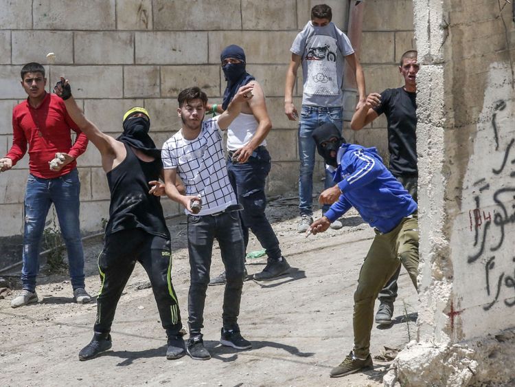Des manifestants palestiniens lancent des pierres lors d'affrontements avec les forces de sécurité israéliennes à la suite d'un enterrement dans le village de Beit Ummar, au nord d'Hébron, dans la ville occupée de Cisjordanie le 14 juillet 2018. (Photo: HAZEM BADER / AFP / Getty Images)
