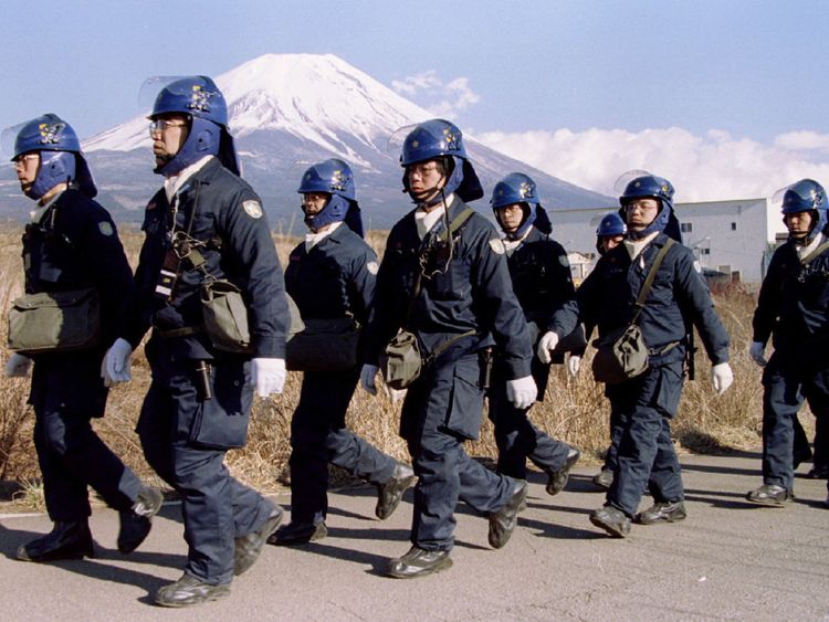 Une équipe de police quitte un complexe Aum Shinri Kyo (Suprême Truth Sect) après avoir terminé leur quart de travail dans le petit village de Kamikuishiki au pied du mont Fuji dans cette photo du 28 mars 1995