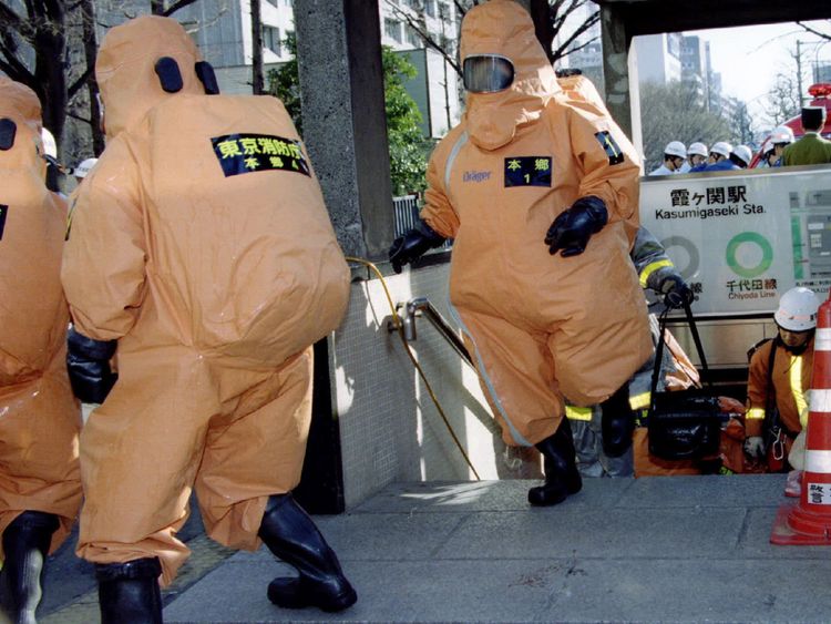 Photo d'un membre d'une unité spéciale de contrôle chimique sortant d'une entrée de la station de métro Kasumigaseki à Tokyo 20 mars 1995