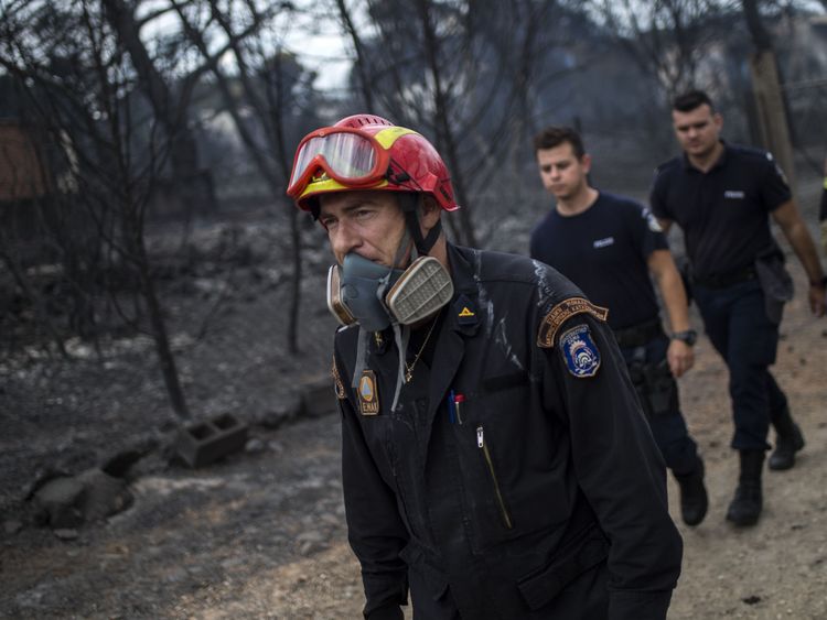 Les sauveteurs arrivent dans la zone où des cadavres ont été retrouvés suite à un incendie dans le village de Mati, près d'Athènes, le 24 juillet 2018