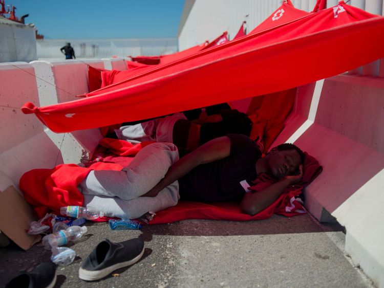 Un homme sauvé en mer avec d'autres migrants repose alors qu'il attend d'être transféré au port d'Algésiras