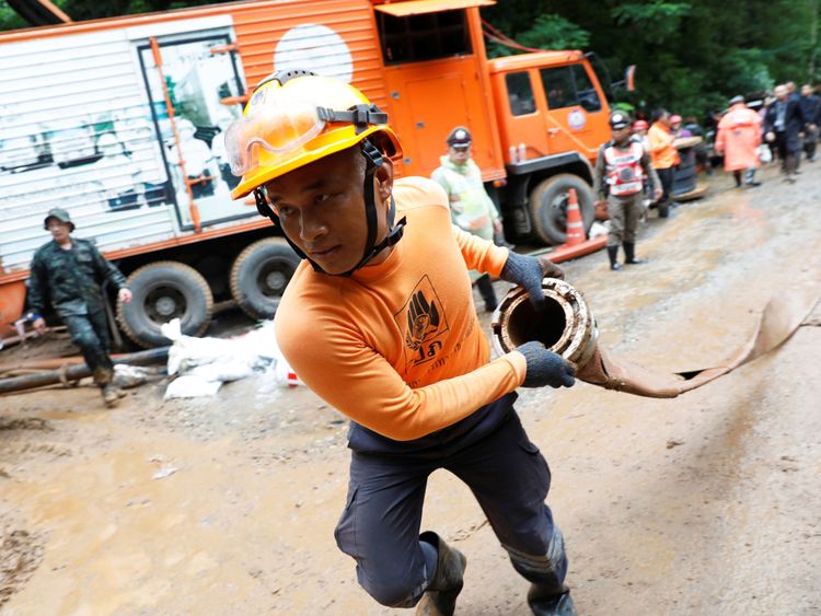 Un membre de l'équipe de secours travaille près du complexe de la grotte Tham Luang, à la recherche de membres d'une équipe de football de moins de 16 ans.