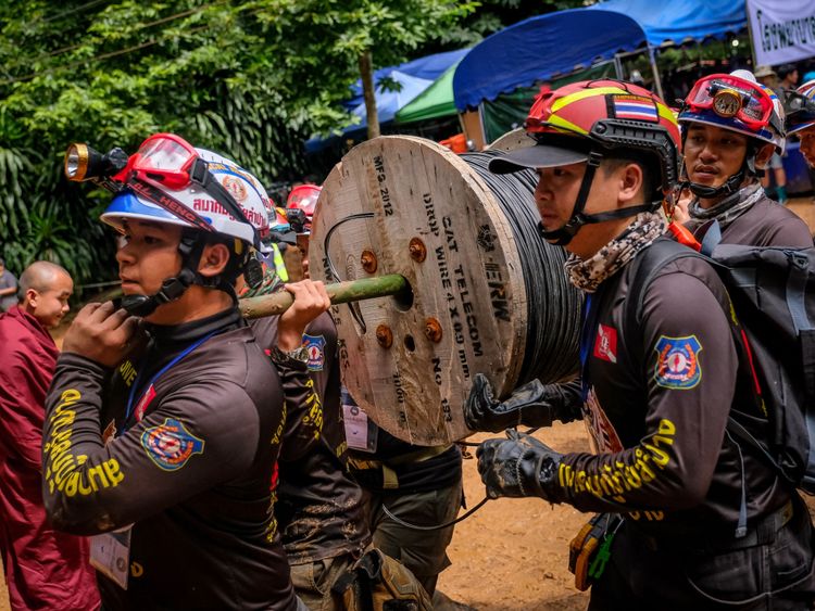 Les secouristes transportent de l'équipement dans le complexe de la grotte